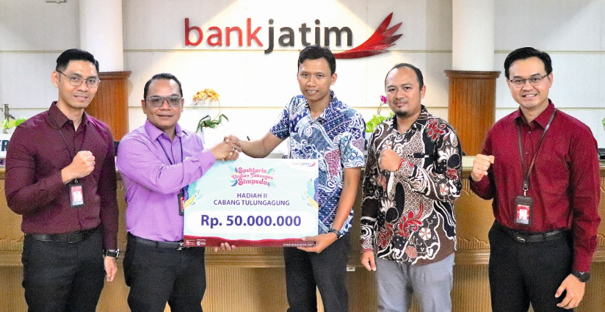 HASIL UNDIAN: Pimpinan Bank Jatim Cabang Tulungagung Murjoko Teguh Hariyanto menyerahkan secara simbolis hadiah utama Rp 100 juta kepada Norma Indah Pratiwi dan Heru Siswanto sebagai pemenang hadiah k