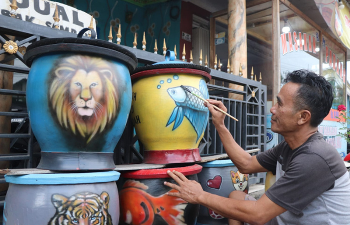 Momen ketika Bambang Mural seekor ikan hias di media tempat sampah.