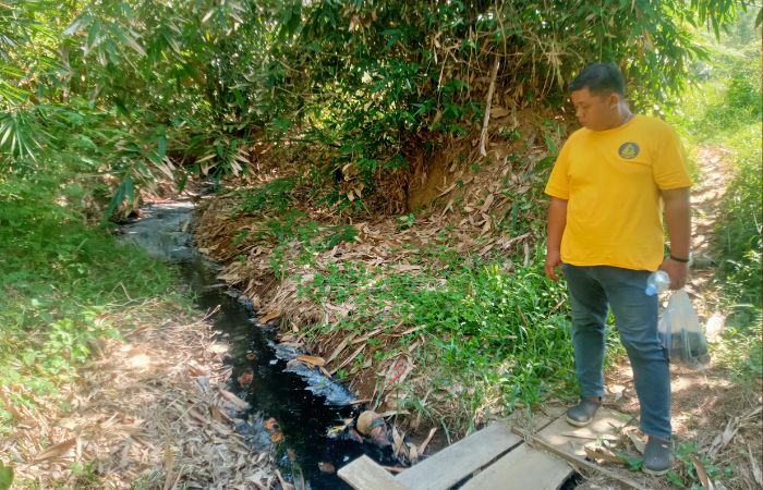 Salah satu warga Desa Margomulyo sedang melihat Sungai Mati yang tercemar oleh limbah hasil pemindangan.