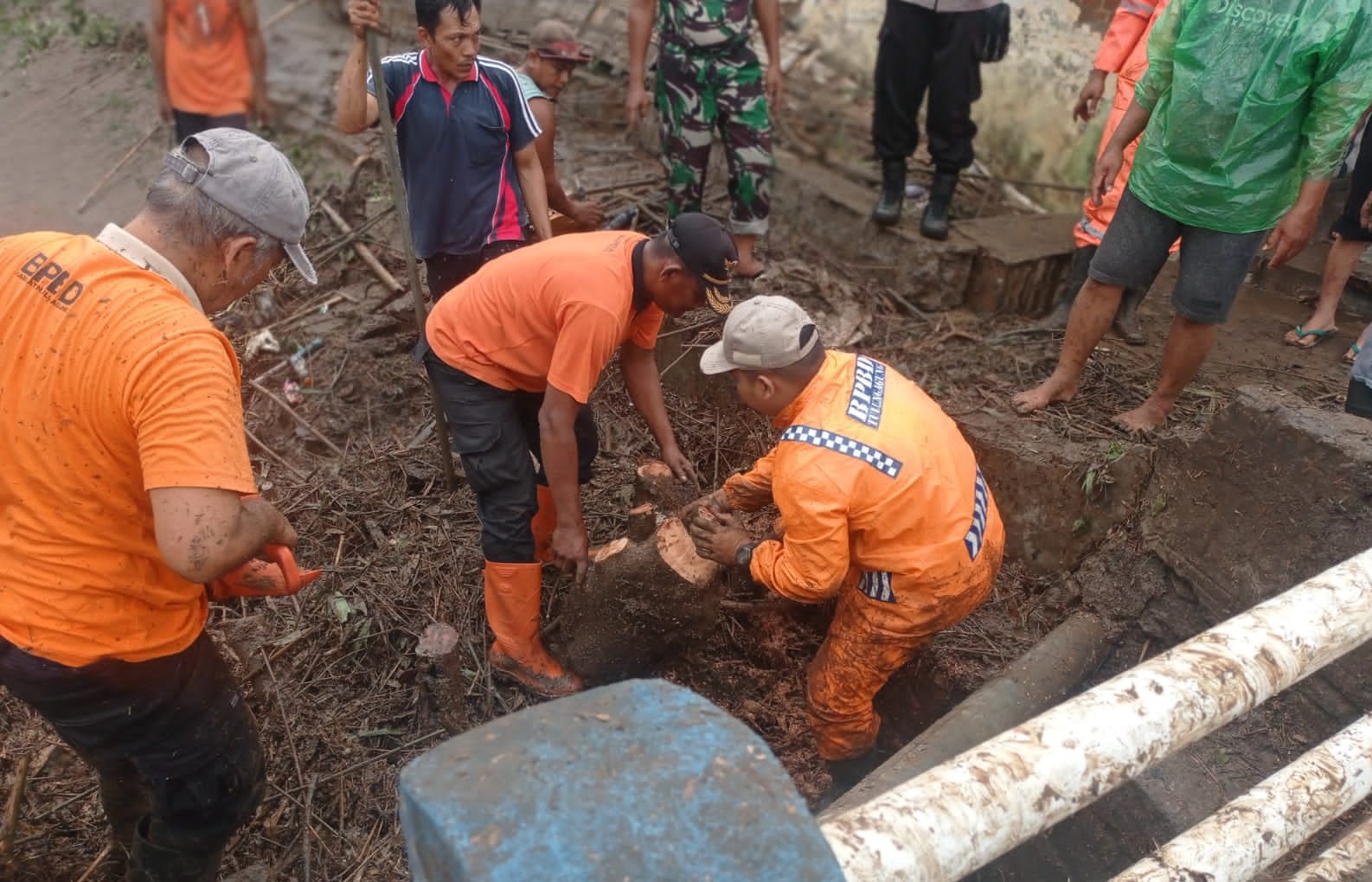 TERSUMBAT: Personel gabungan membersihkan sampah yang menumpuk di bawah jembatan di Desa Joho, Kecamatan Kalidawir pada Sabtu (27/1). (BPBD TULUNGAGUNG UNTUK RADAR TULUNGAGUNG)
