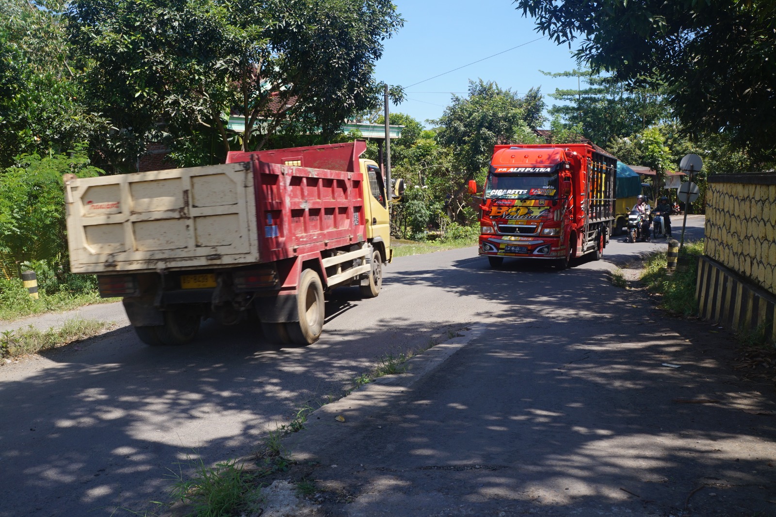 Truk yang mengangkut berbagai jenis barang melintas di jalan raya.