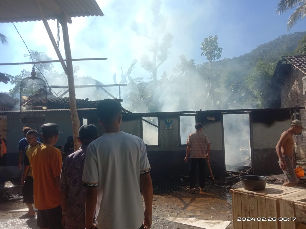 Sejumlah warga melihat kondisi rumah yang terbakar di Desa Pakel, Watulimo