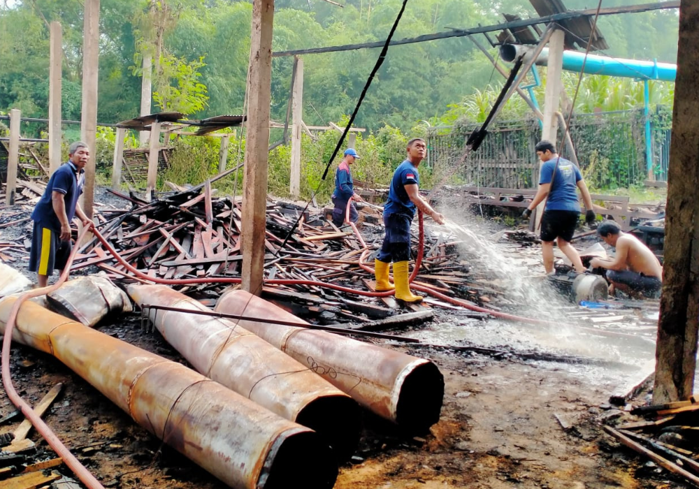 Sejumlah petugas sedang melakukan pendinginan pasca kobaran api meludeskan Pabrik Kayu berhasil ditaklukkan.