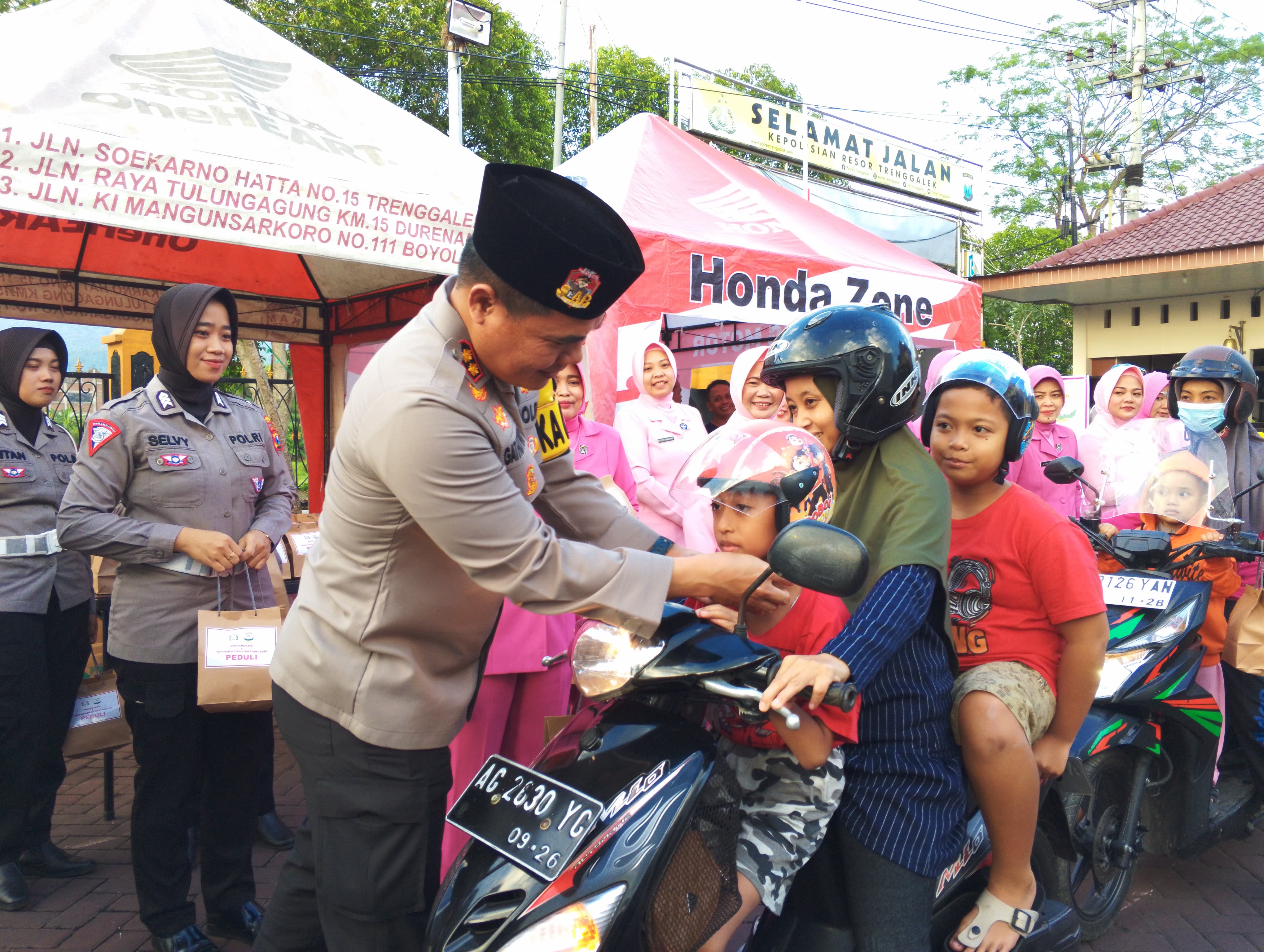 Kapolres Trenggalek AKBP Gathut Bowo Supriyono memakaikan helm kepada seorang anak