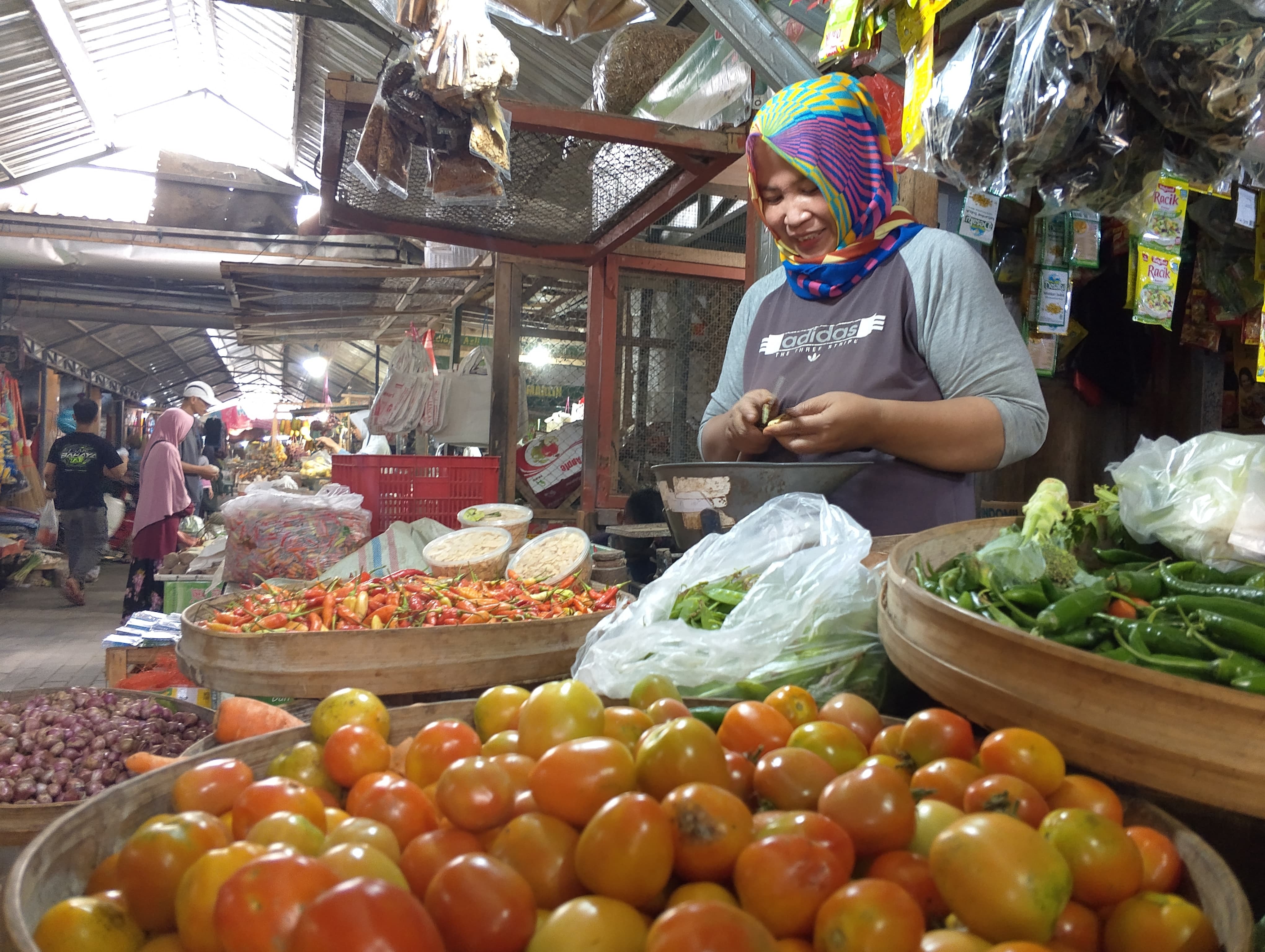 SENYUM: Salah seorang pedagang menunggu pembeli datang. Biaya hidup setiap orang bisa saja berbeda.