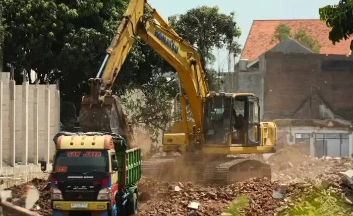 Satu unit backhoe meratakan bangunan di Jl Mayor Bismo yang terdampak pembangunan Tol Kediri-Tulungagung