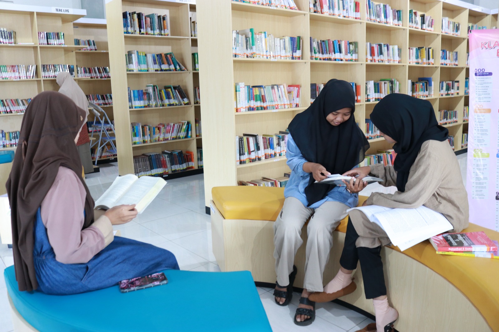 ANTUSIAS: Sejumlah pengunjung perpustakaan membaca buku sambil duduk di kursi.