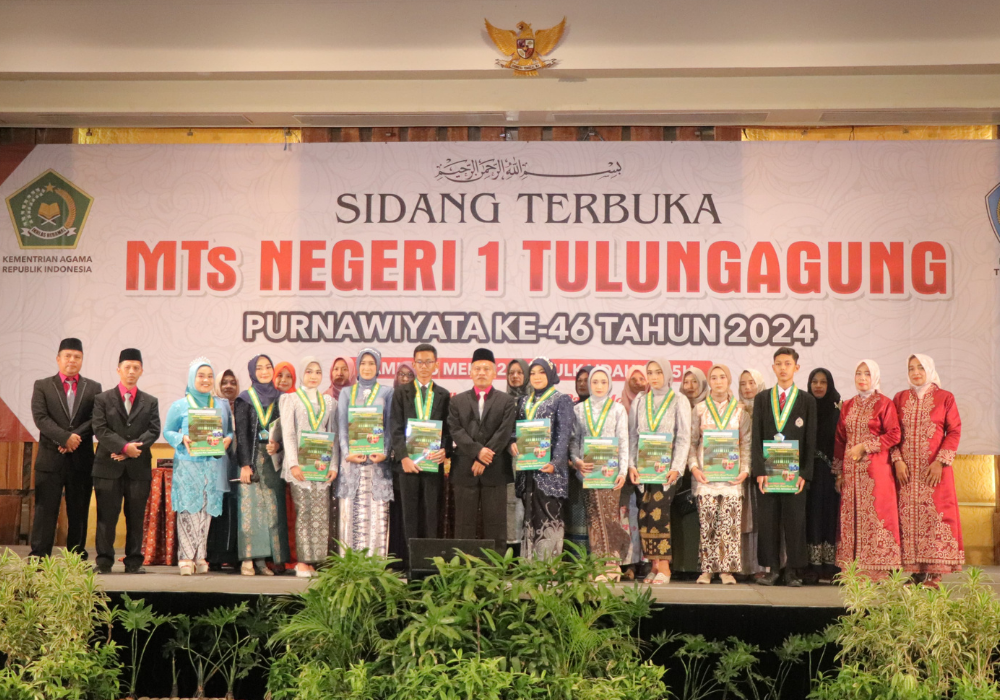 KOMPAK: Kepala MTsN 1 Tulungagung, Muhibuddin bersama puluhan siswa peraih prestasi bersua foto dalam momen wisuda purnawiyata.