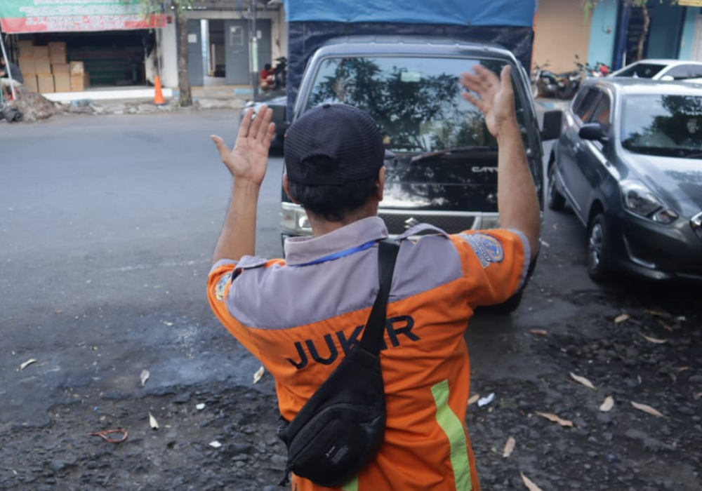 Petugas parkir mengarahkan pelanggan di salah satu titik parkir tepi jalan umum di Tulungagung