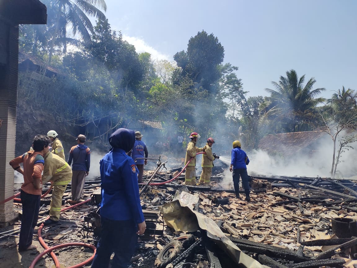 TINGGAL PUING: Tim gabungan berupaya memadamkan api yang membakar rumah warga.
