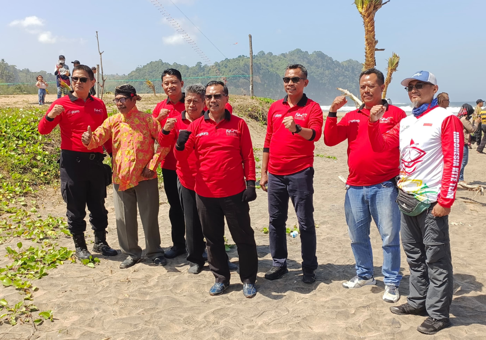 TARIK: Kades Rejosari Sudikan dan para tamu undangan saat festival layang-layang di Pantai Dlodo, Minggu (21/7/2024).