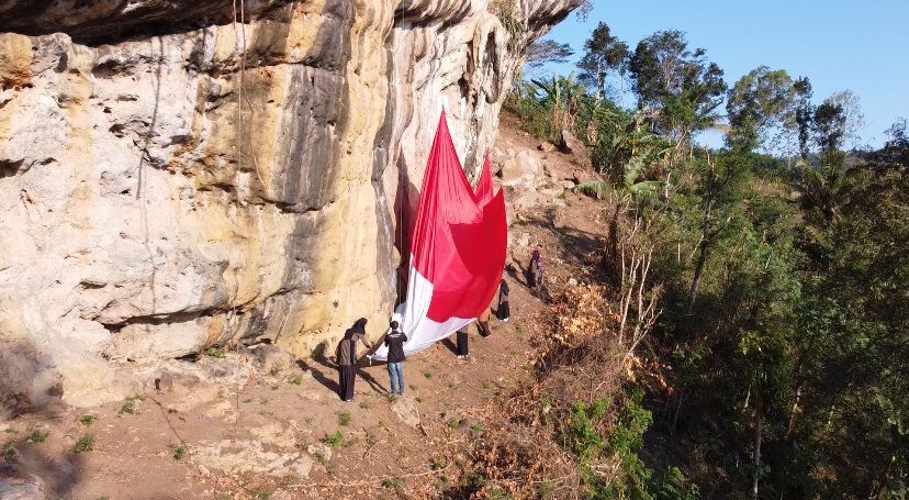HATI_HATI: Para pemanjat tebing persiapan membentangkan bendera di tebing belik wolu