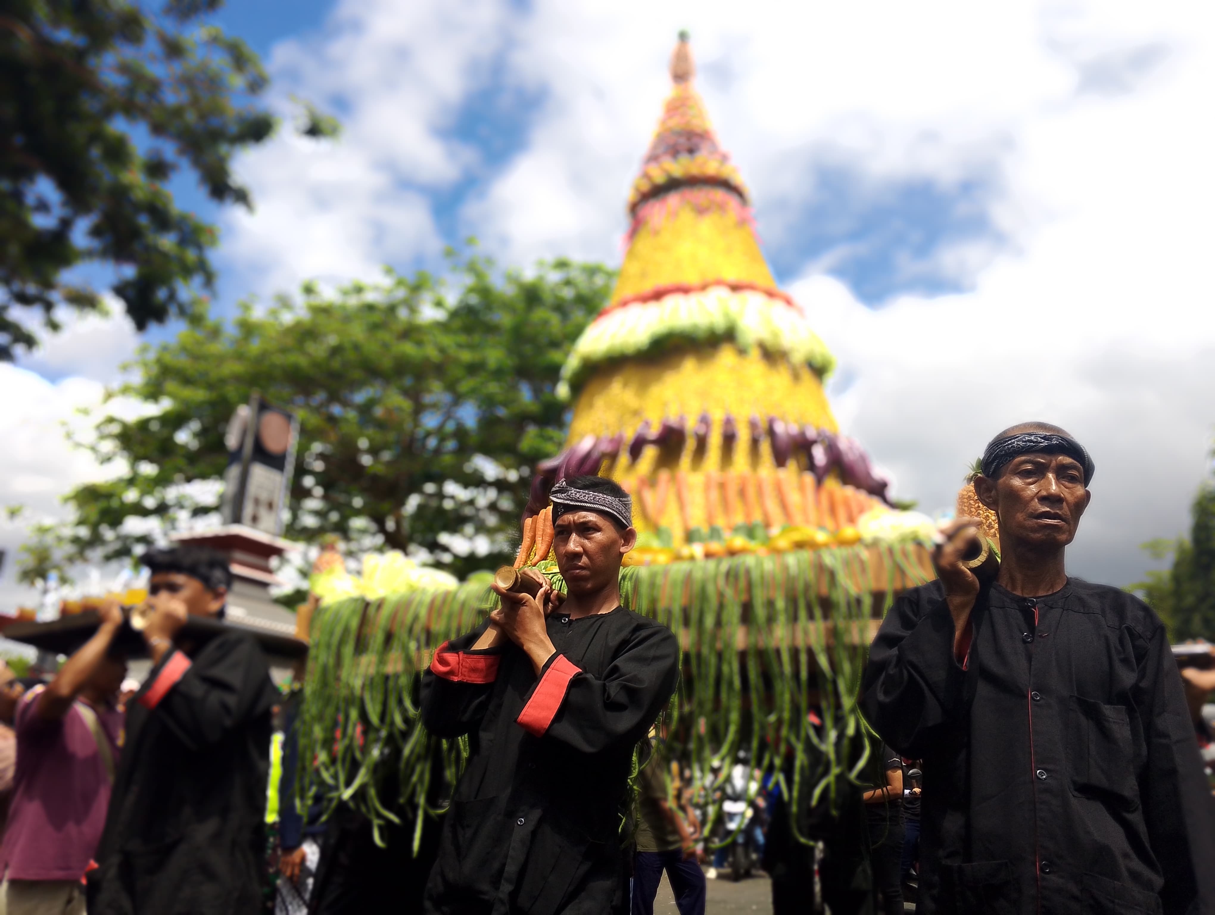KUAT: Sejumlah orang menggotong tumpeng raksasa.