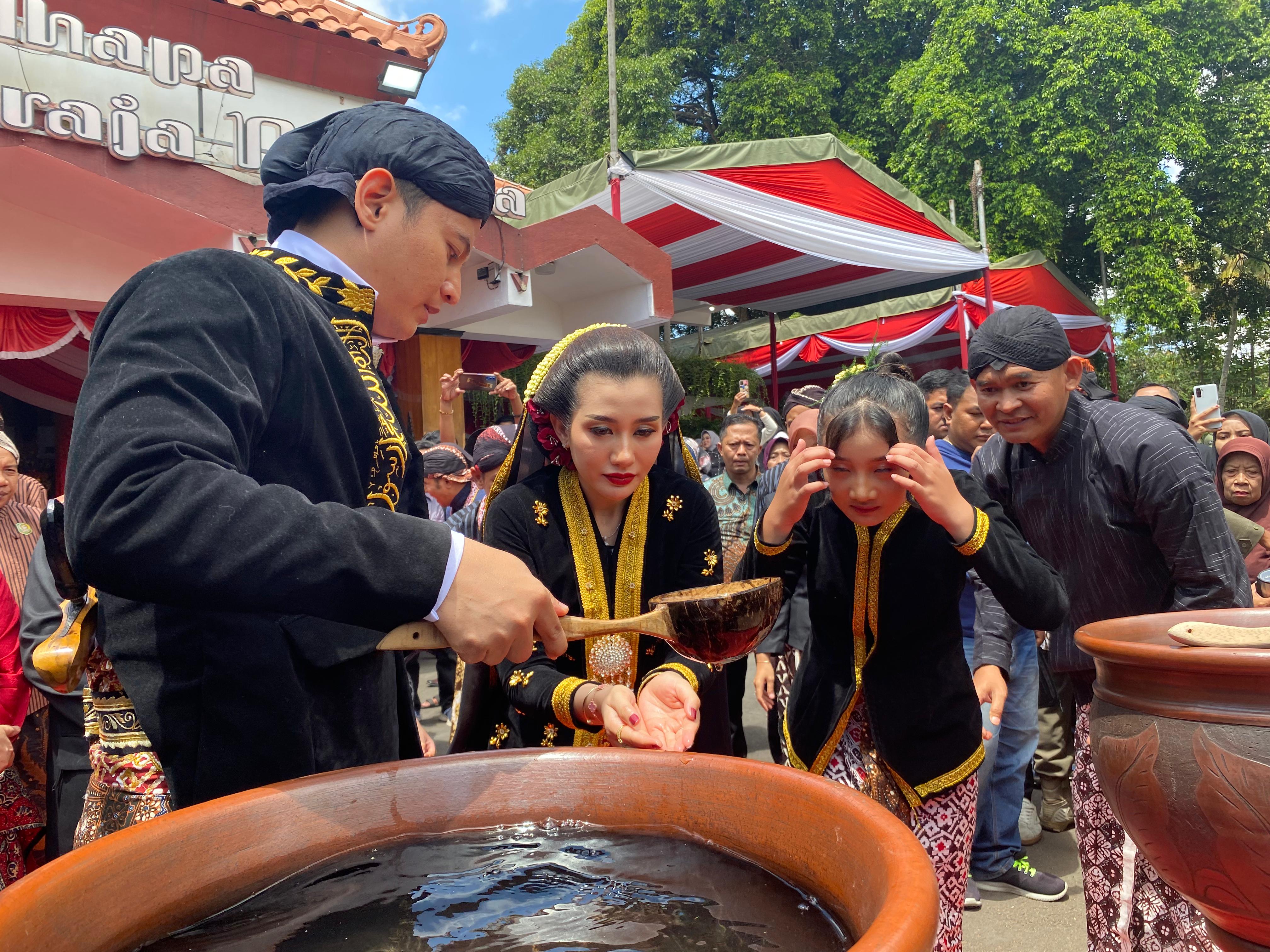 MENYEJUKKAN: Bupati Trenggalek Mochamad Nur Arifin menuangkan gayung berisi air dari tujuh sumber untuk istri dan putri sulungnya.