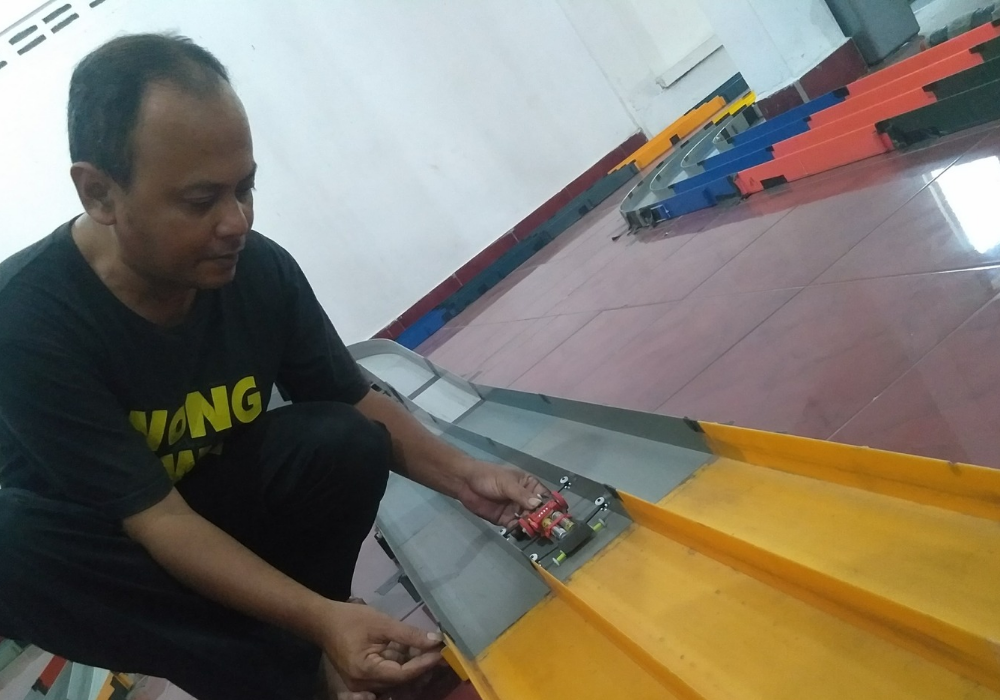 Bayu Cahyoadi mencoba salah satu miniatur mobilnya di lintasan mini 4 WD-nya.