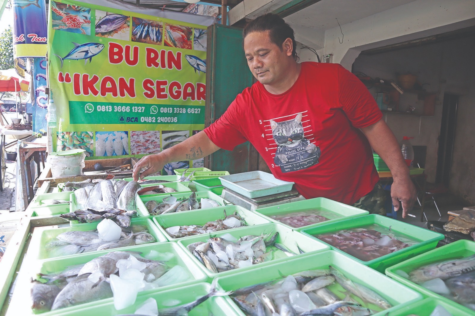 Pedagang ikan segar di Pasar Ngemplak sedang menata dagangan