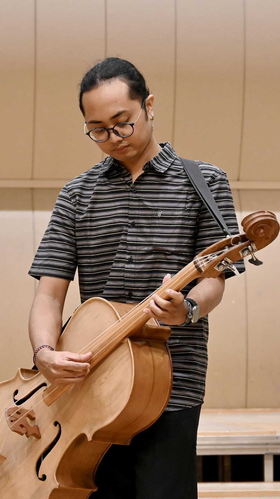 SEMANGAT: Satriyo Bagus Wicaksono memainkan salah satu alat musik yang dipakai untuk keroncong