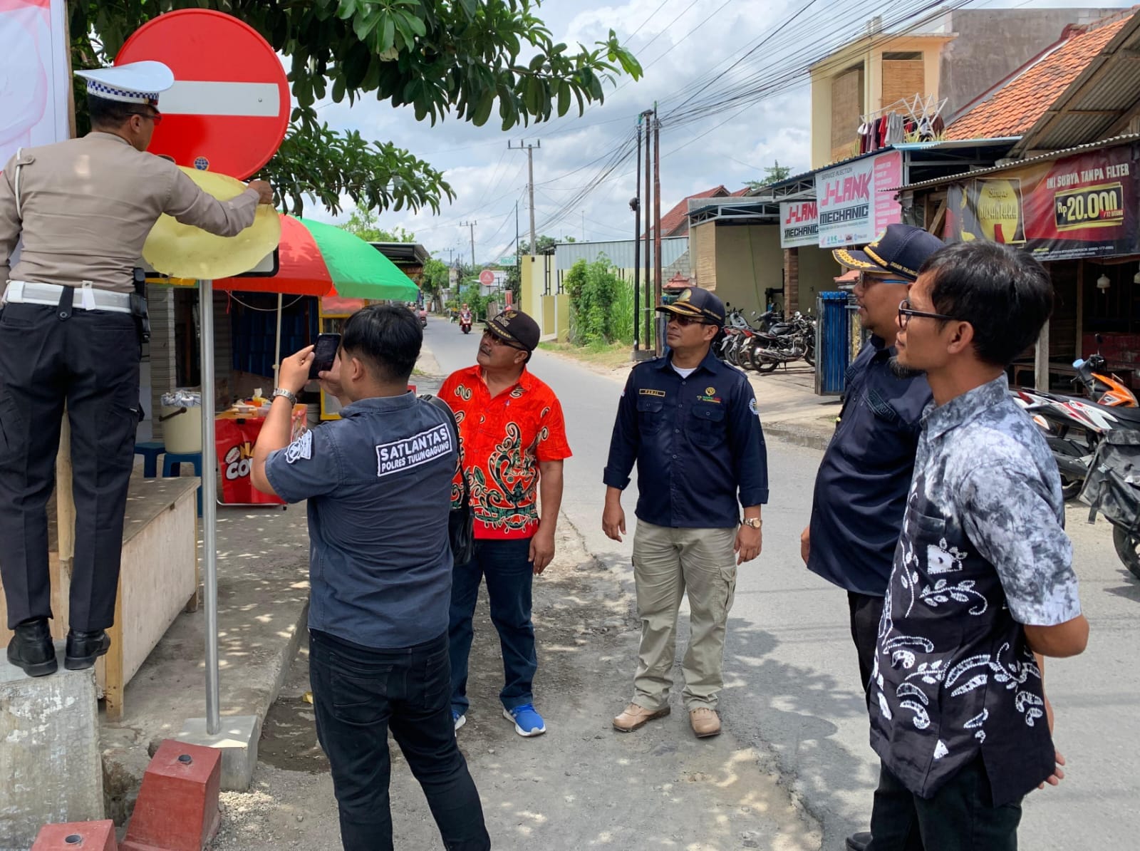 Petugas gabungan memasang rambu baru di ruas Jalan Raya Plosokandang yang mulai difungsikan satu arah. (DISHUB TULUNGAGUNG UNTUK RADAR TULUNGAGUNG)