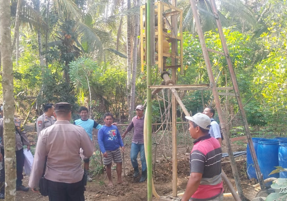 GOTONG ROTONG: Warga bersama dengan polisi bersama-sama membangun sumur bor di Desa Kalibatur.