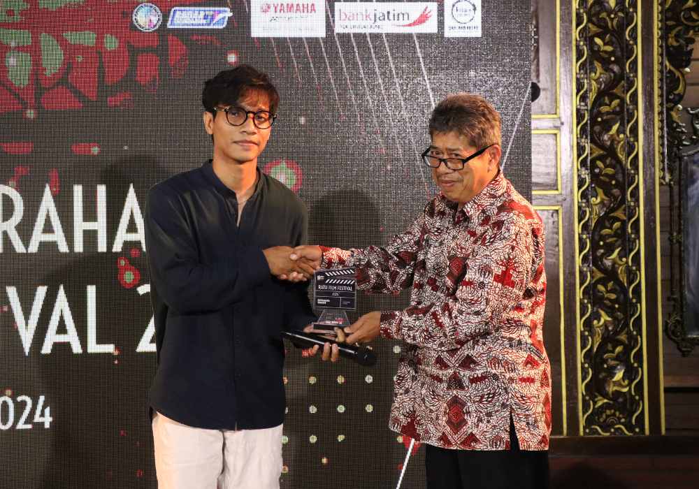 BERJAYA: Kepala Disbudpar Tulungagung Bambang Ermawan (batik) menyerahkan piagam Sutradara Terbaik kategori Umum kepada pemenang yang bernama Luciano Paganini, yang diwakilkan timnya, dengan film yang