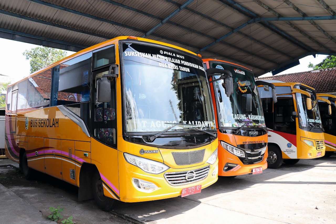 Beberapa bus sekolah terpakir rapi di garasi.