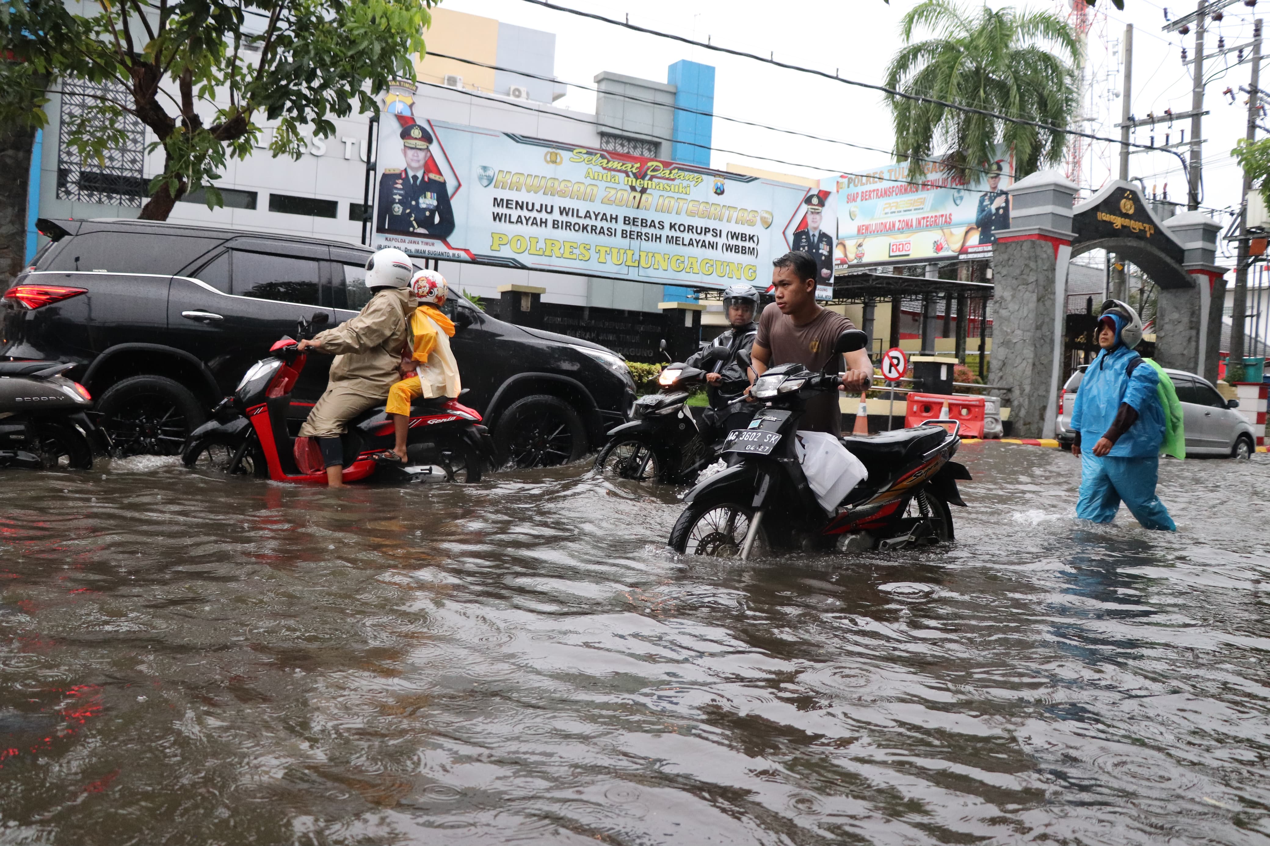 Personel Satsabhara Polres Tulungagung membantu pengendara sepeda motor yang mogok . (YOGA DD/RADAR TULUNGAGUNG)