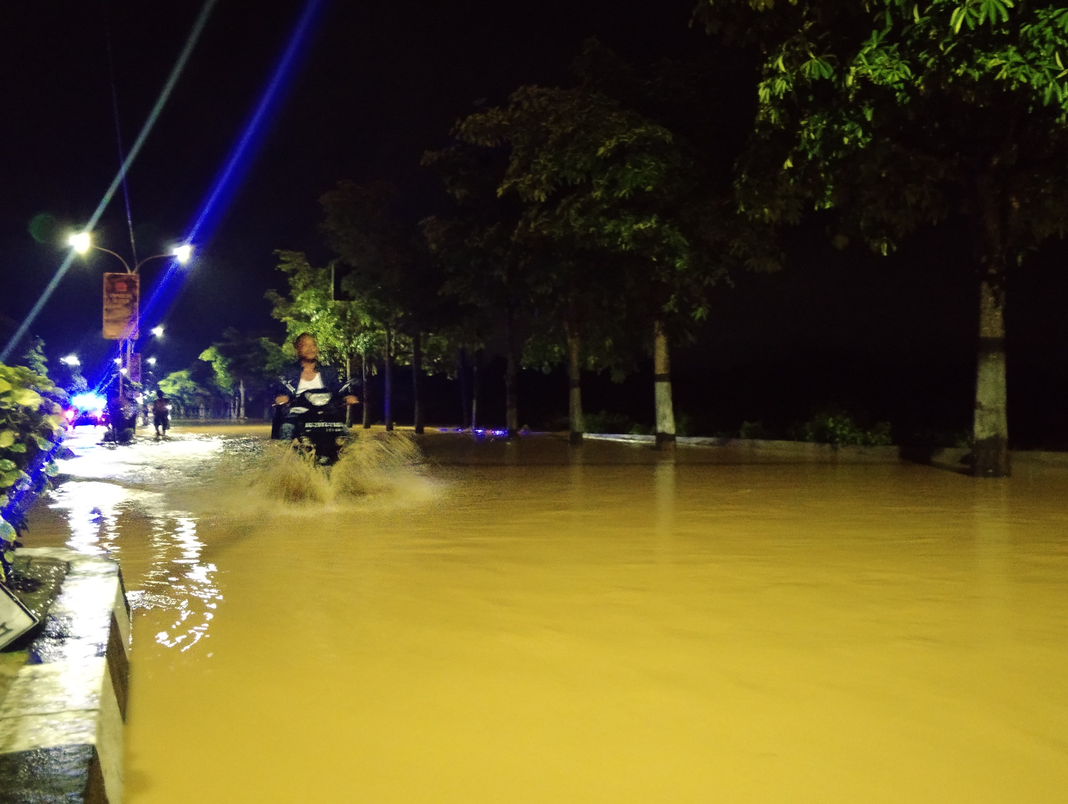 TERGENANG: Pemotor melintas di ruas jalan  depan SPBU Kelutan yang terdampak banjir.
