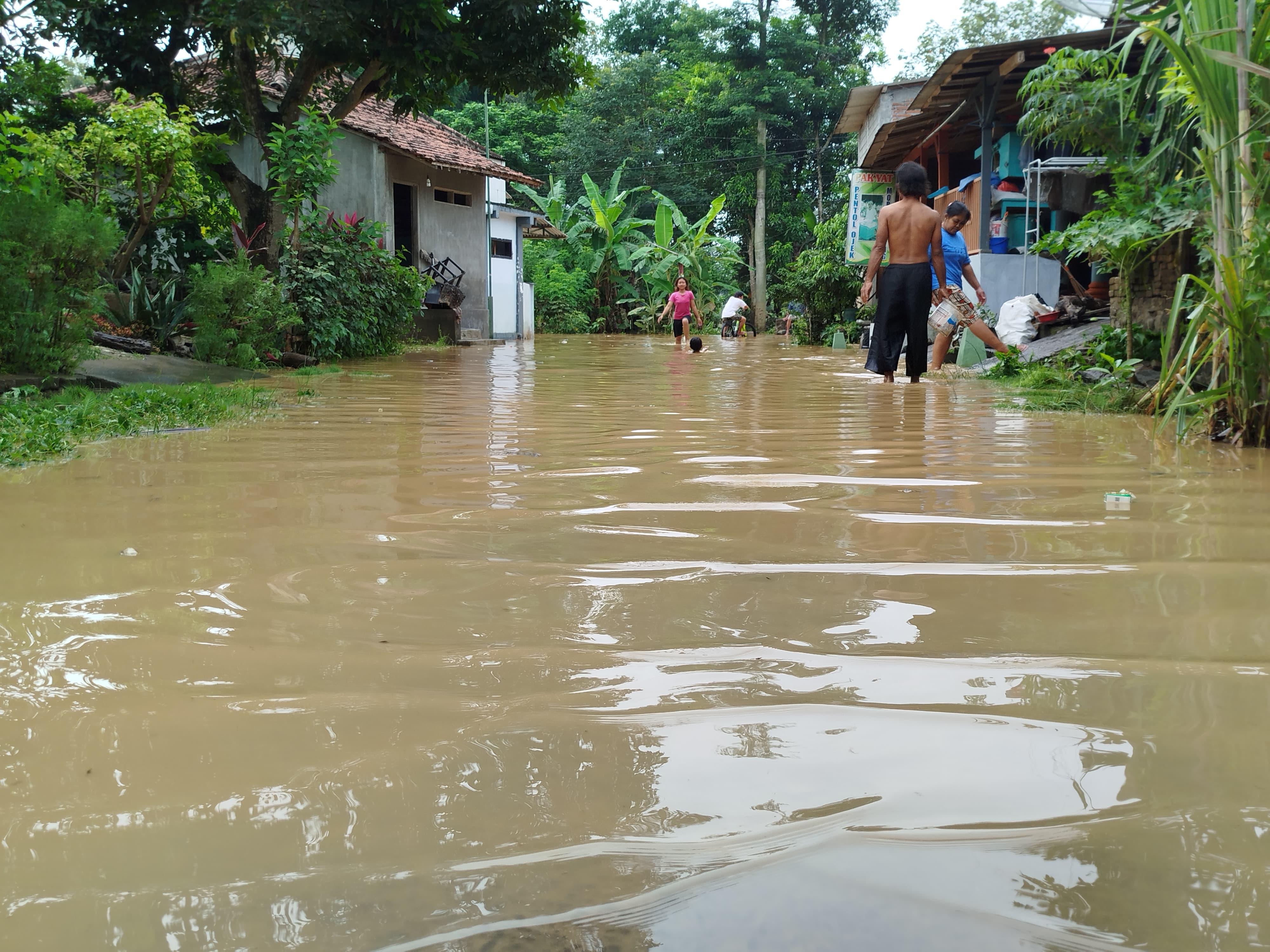 BERLUMPUR: Salah satu ruas jalan di Kelurahan Tamanan yang juga terdampak banjir.