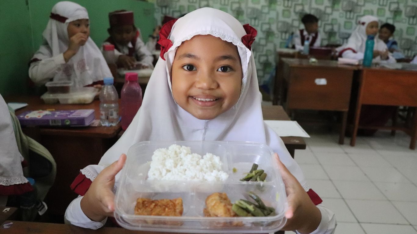 Salah satu siswi SD Islam Al Azhaar menunjukkan menu Makanan Bergizi Gratis (MBG).(YOGA DANY DAMARA/RADAR TULUNGAGUNG)