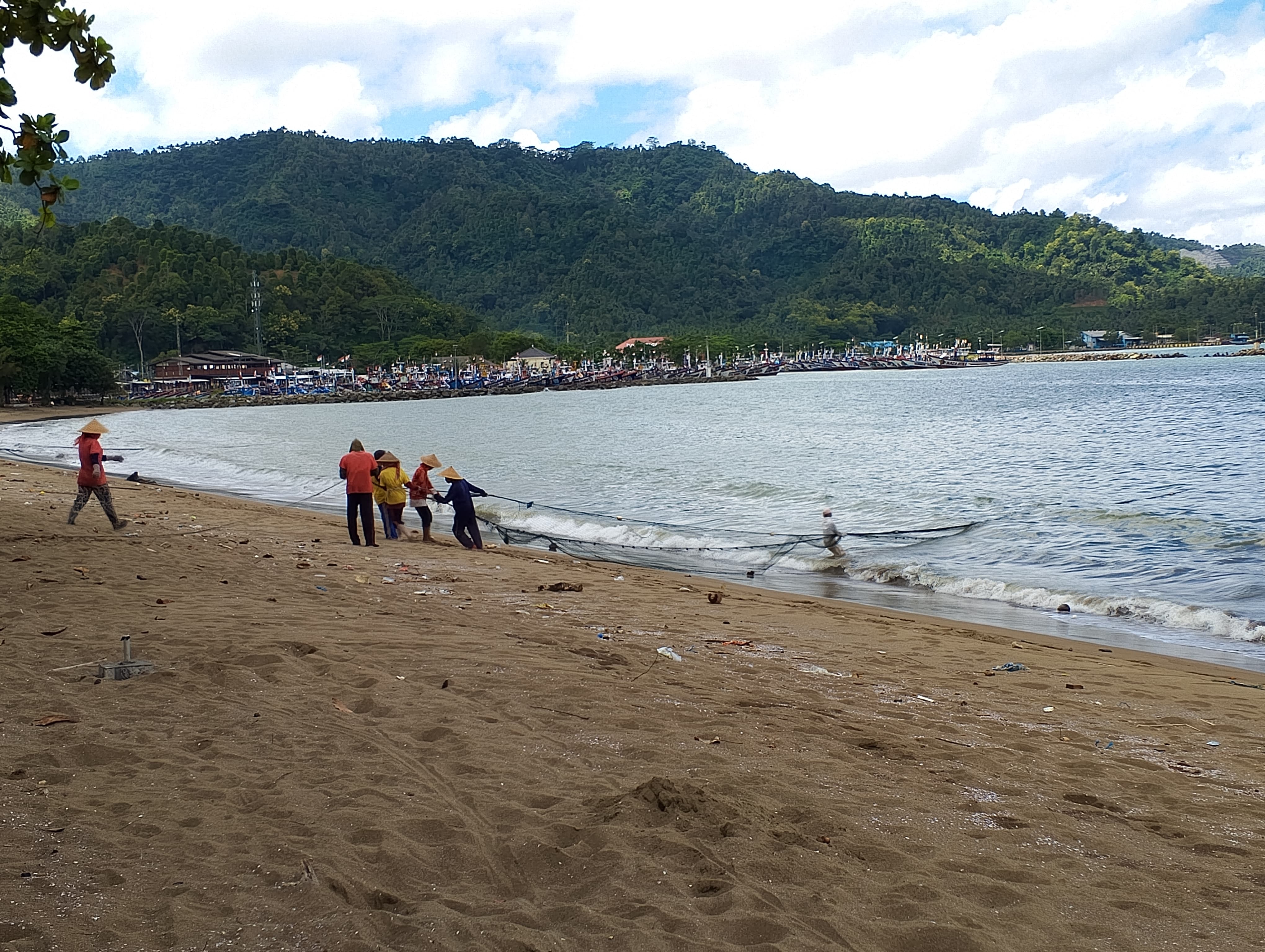 SEMANGAT: Nelayan di Pantai Prigi menarik jaring untuk menangkap ikan.