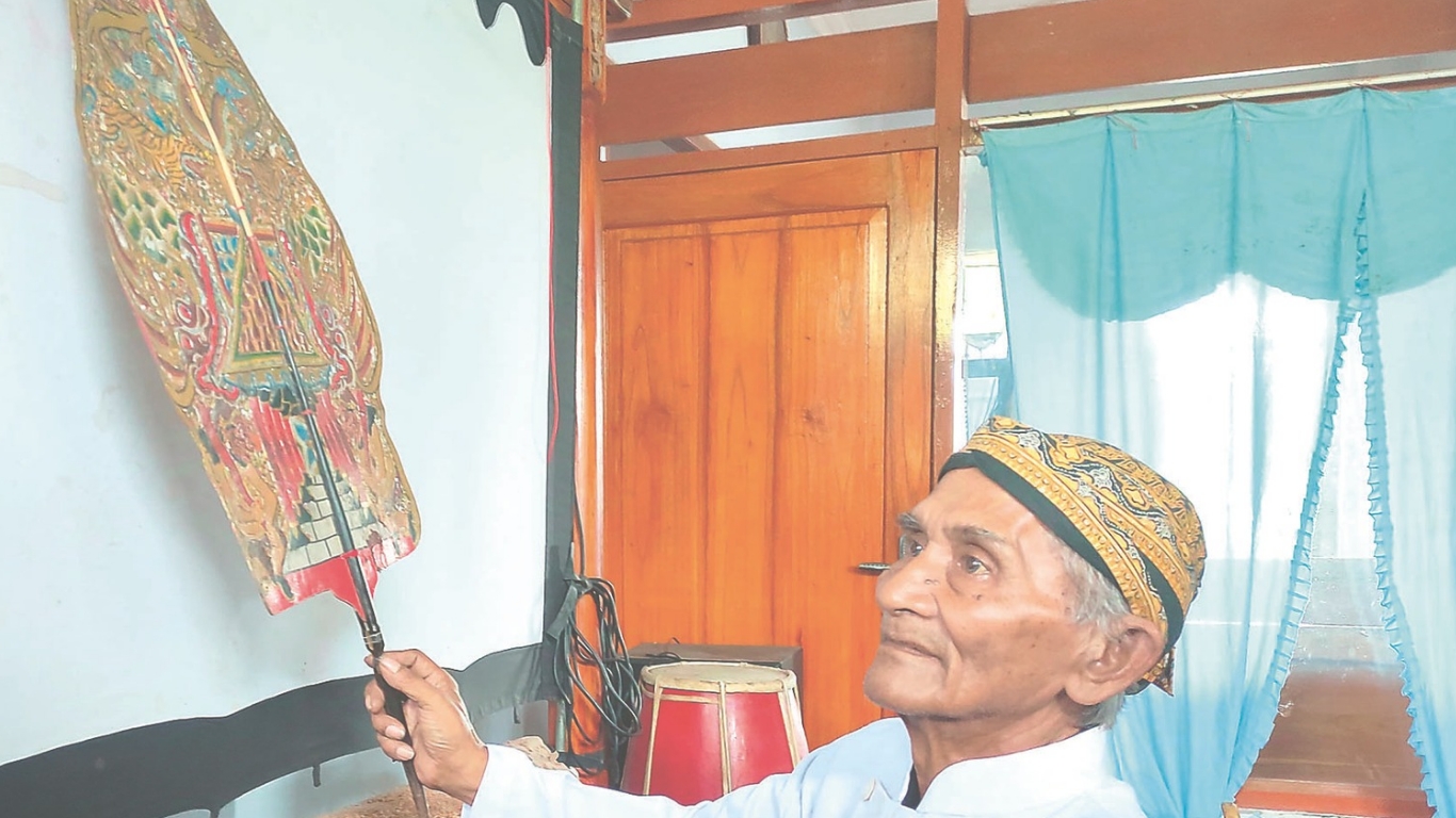 Ki Marjuki Mardi Sabdo saat menunjukkan koleksi wayang miliknya.