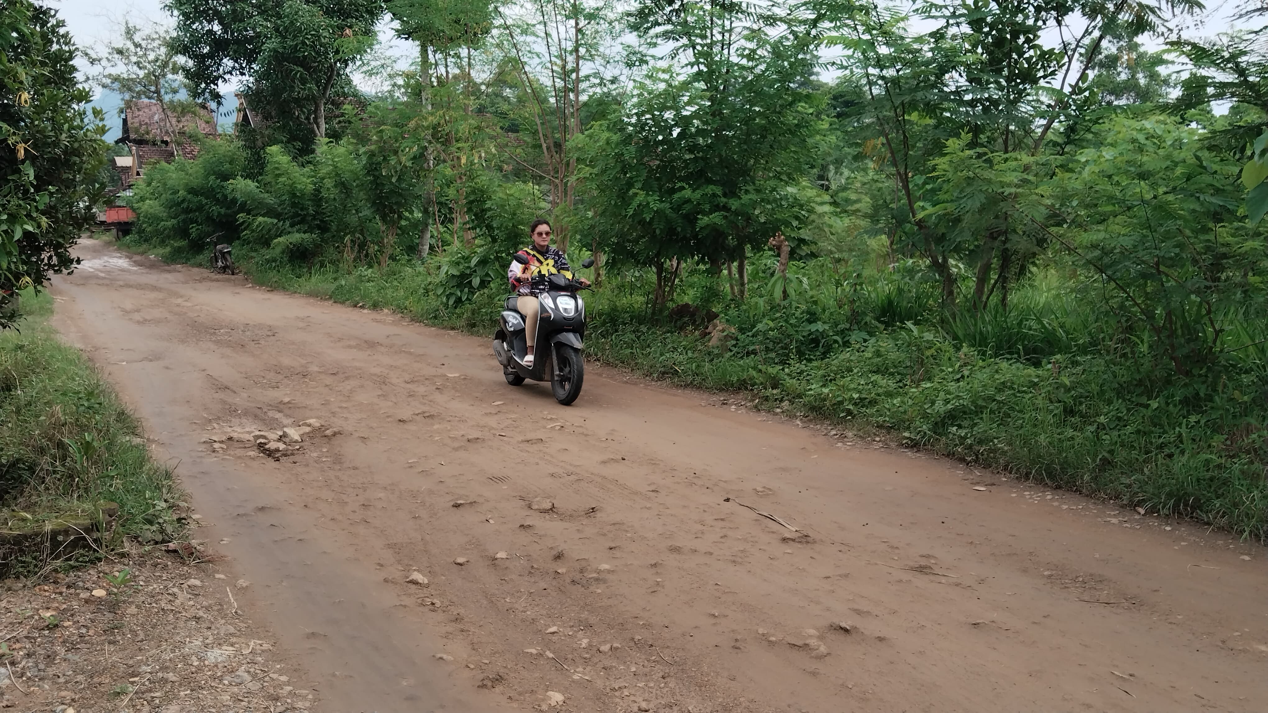 LICIN SAAT HUJAN: Pengendara motor melintasi jalur Desa Gador, Kecamatan Durenan.
