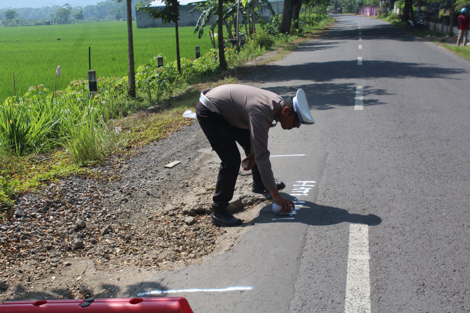 Personel Satlantas Polres Trenggalek menandai dengan cat titik jalan yang rusak. (Polres Trenggalek)