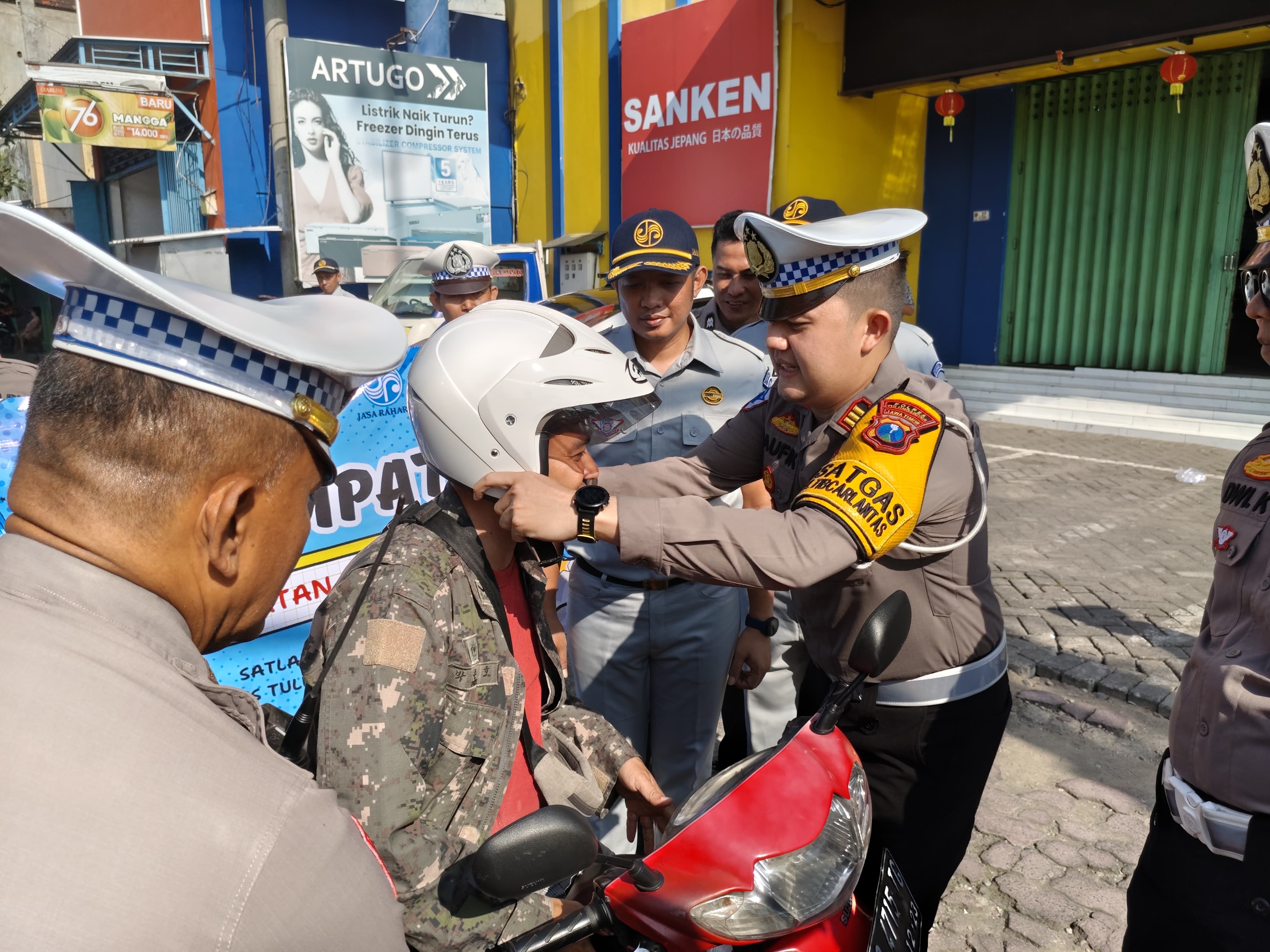 Kasatlantas Polres Tulungagung bagikan helm SNI dan coklat pada aksi simpatik operasi keselamatan semeru 2025 di Tulungagung