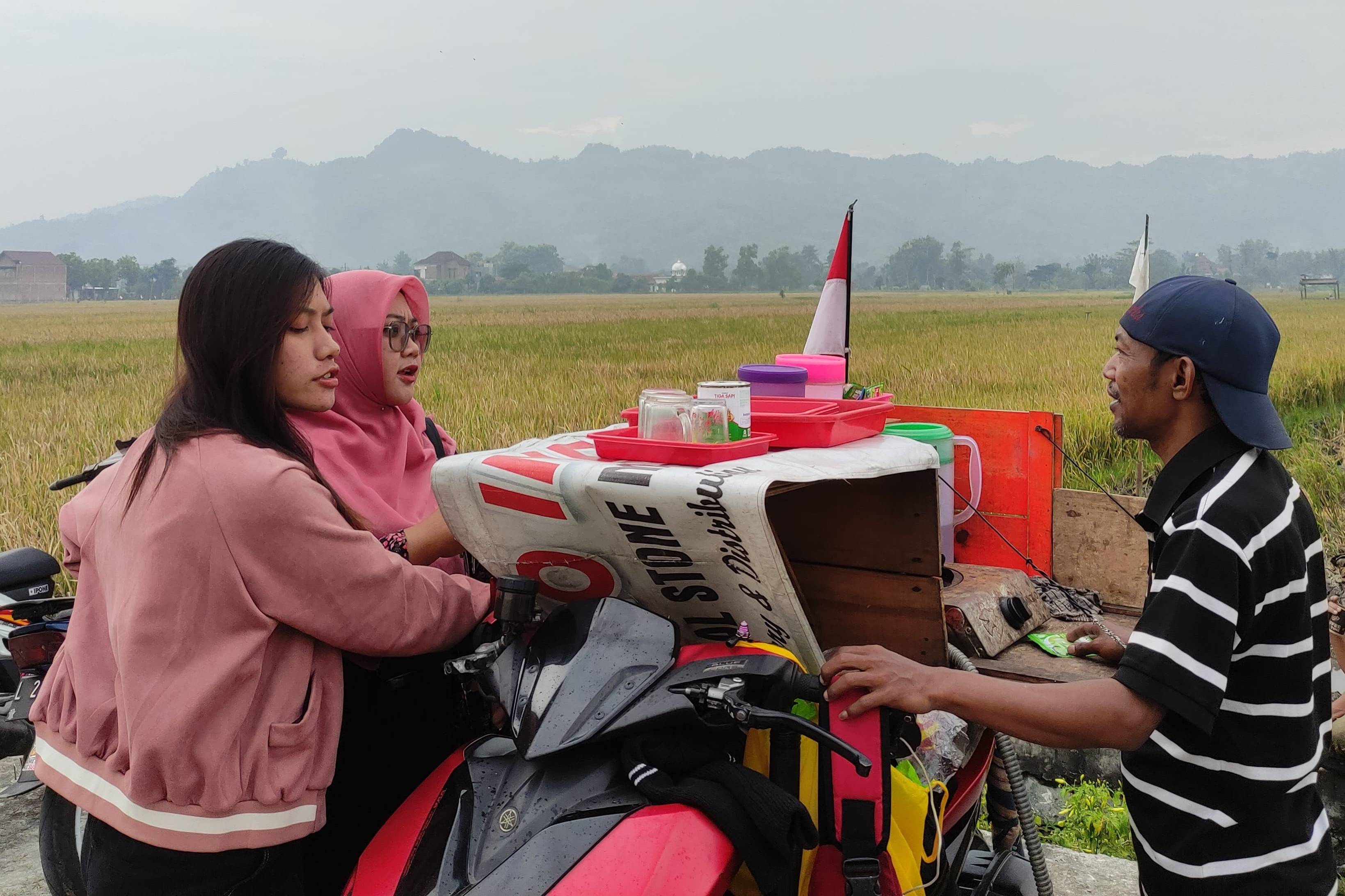 Penjual kopi keliling di Desa Sanggrahan, Kecamatan Boyolangu melayani penjual (SANDY YUWANA/RADAR TULUNGAGUNG)