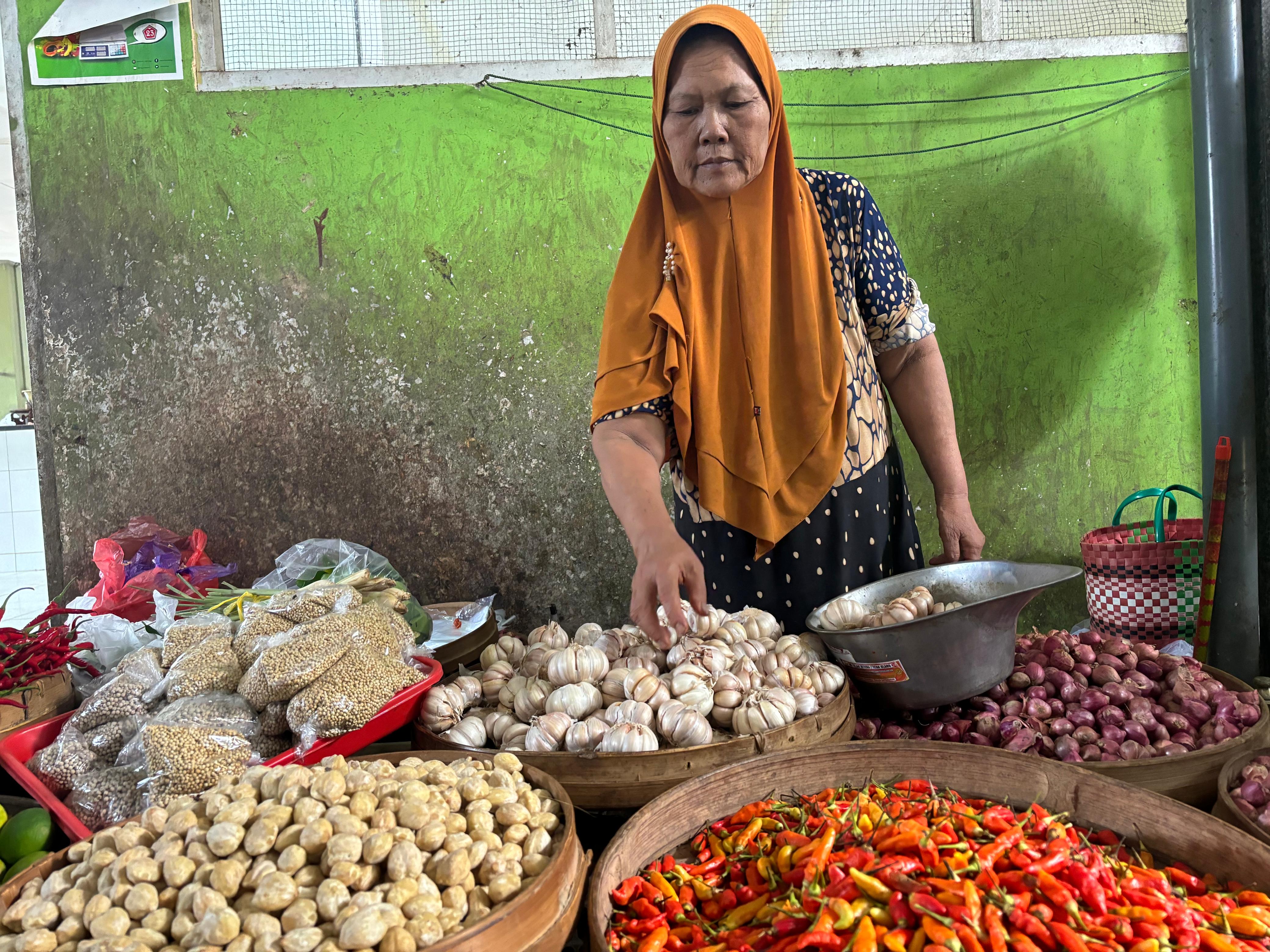 Pedagang Pasar Basah Trenggalek tetap berjualan meski harga bawang putih melonjak.