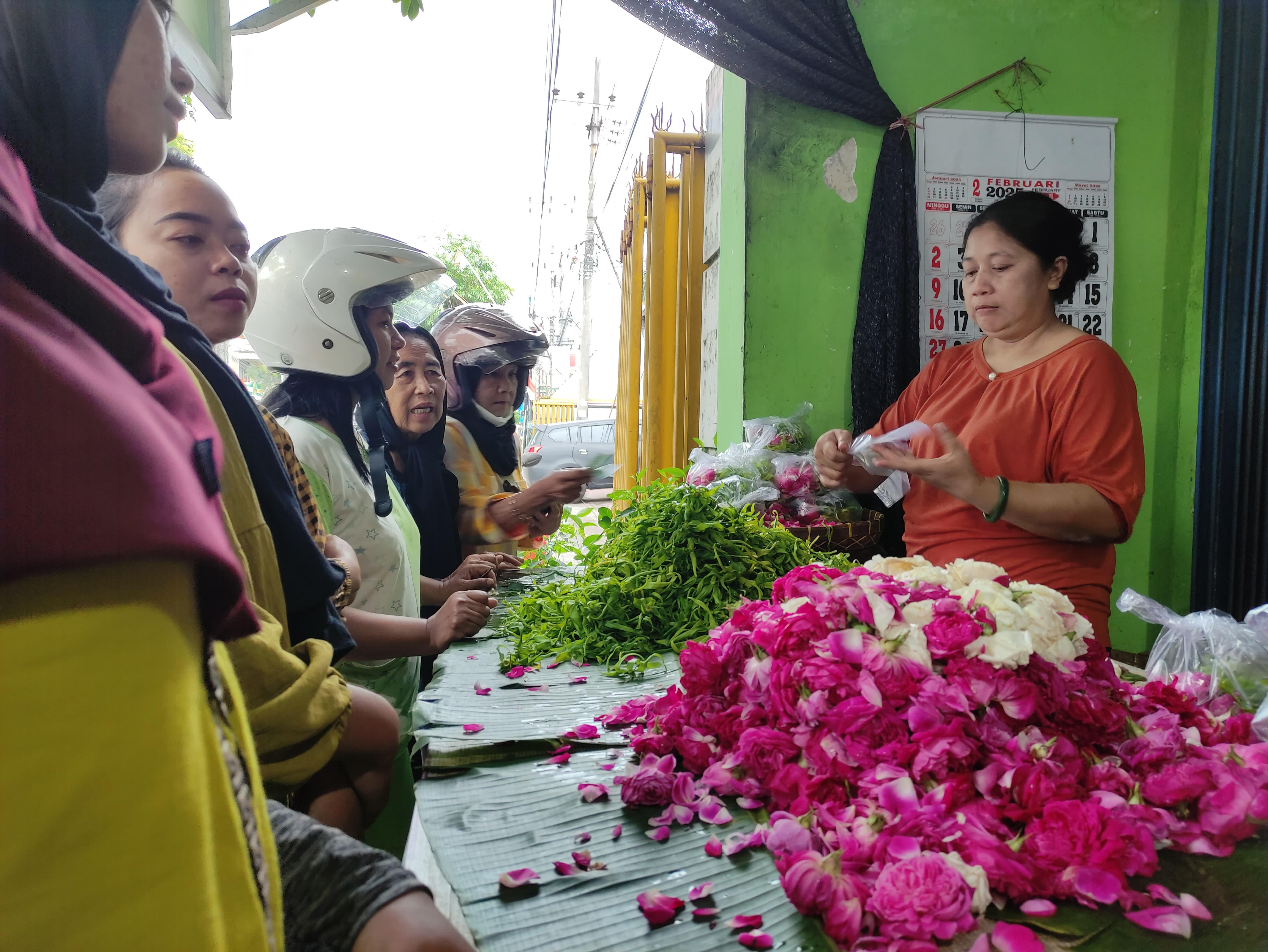 Salah satu pedagang  bunga tabur makam di Kelurahan Kepatihan, Kecamatan Tulungagung sedang melayani pembeli (SANDY YUWANA/RADAR TULUNGAGUNG)