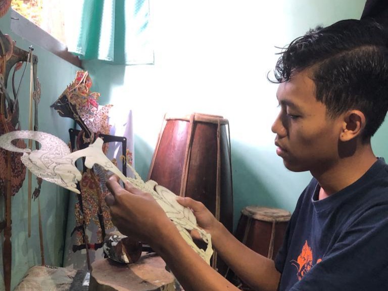 Kresna Sugiantoro dalam proses pembuatan salah satu tokok wayang.