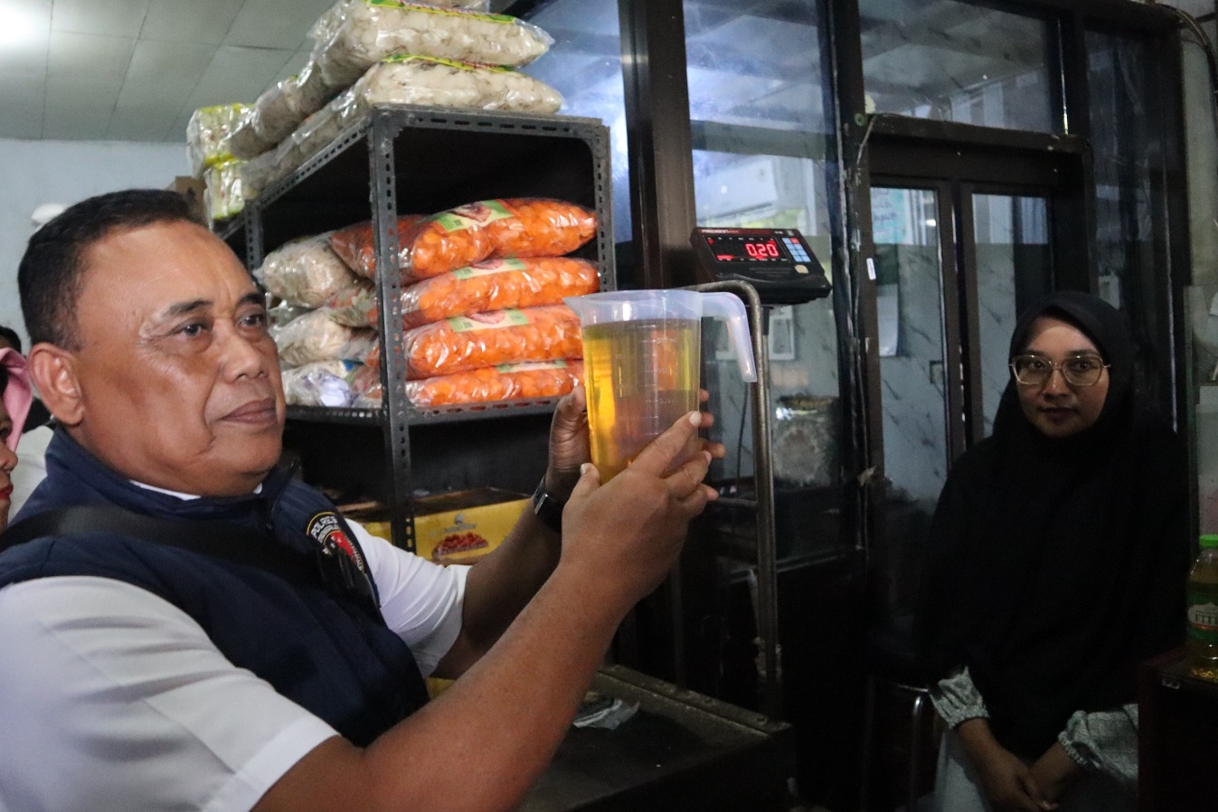 KBO Reskrim Polres Trenggalek Iptu Singgih Marsudi memperlihatkan takaran minyak yang pas 1 liter. (HUMAS POLRES TRENGGALEK)
