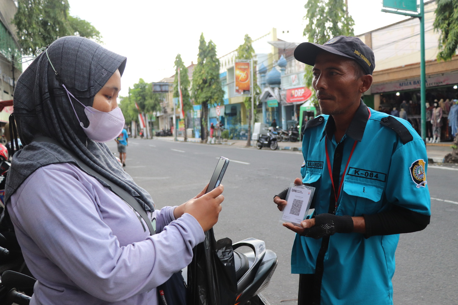 Pelanggan membayar retribusi nontunai kepada juru parkir di Jalan Pangeran Diponegoro beberapa waktu lalu.
