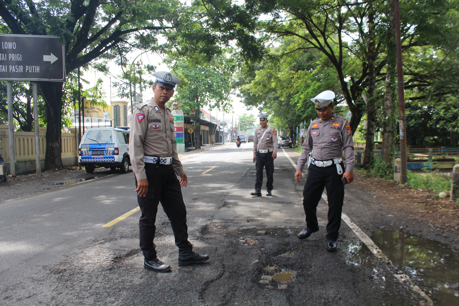 Personel Satlantas Polres Trenggalek mengecek kondisi jalan nasional di Durenan. (polrestrenggalek.com)