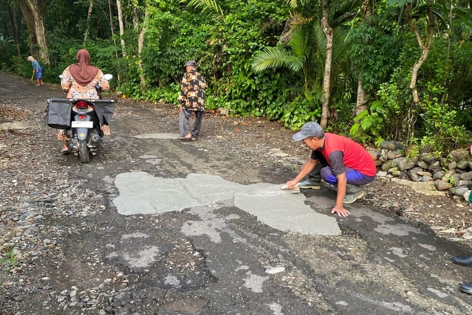Warga Desa Ngadimulyo, Kecamatan Kampak, Trenggalek memperbaiki jalan secara swadaya. (ISTIMEWA)