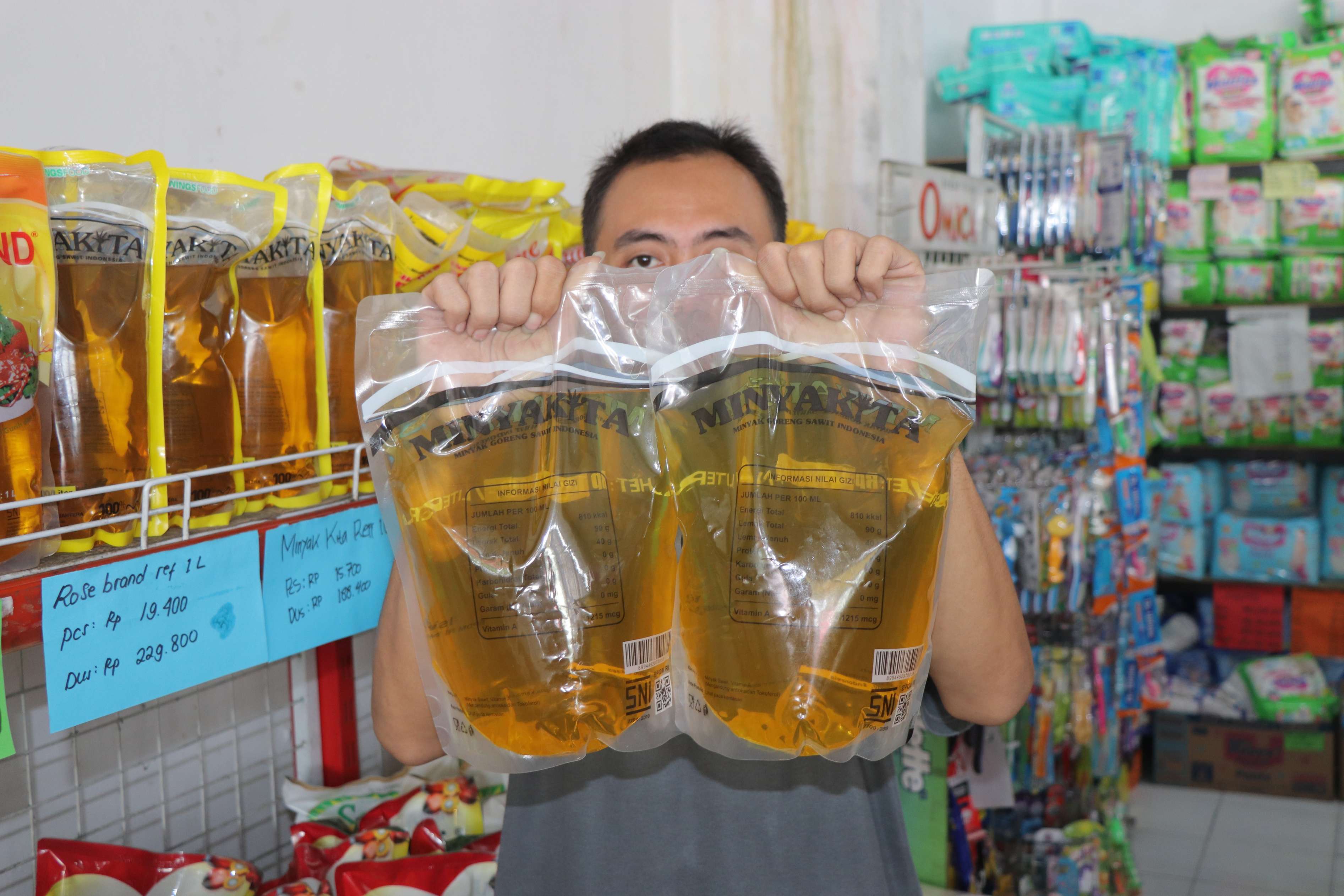 Karyawan toko di Desa Bolorejo, Kecamatan Kauman, Tulungagung menunjukkan stok MinyaKita. (YOGA DD/RADAR TULUNGAGUNG)