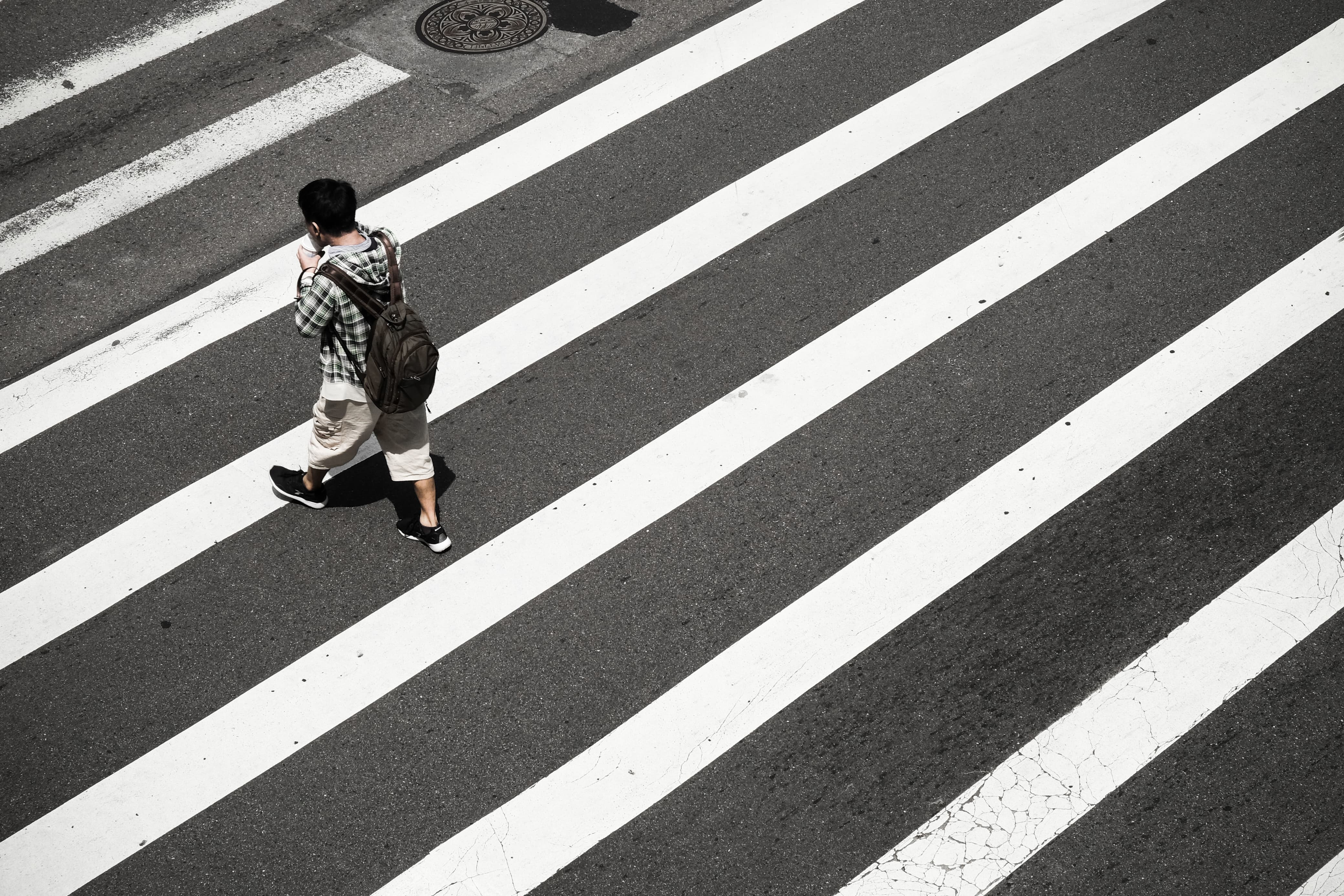 Seorang fotografer sedang memotret orang menyebrang jalan di jalan zebra cross