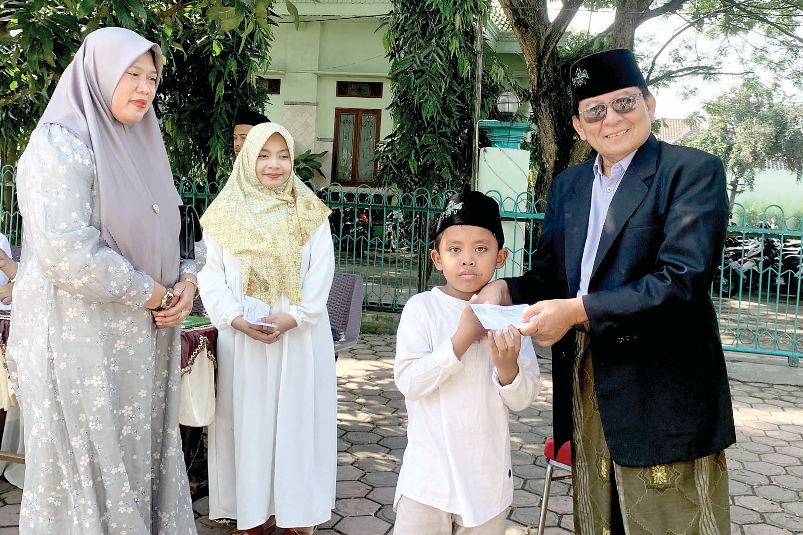 SEMOGA BERMANFAAT: H Syamsul Laily sedang memberikan santunan kepada anak yatim dan kaum duafa di pondok pesantren miliknya. (SANDY YUWANA/RADAR TULUNGAGUNG)
