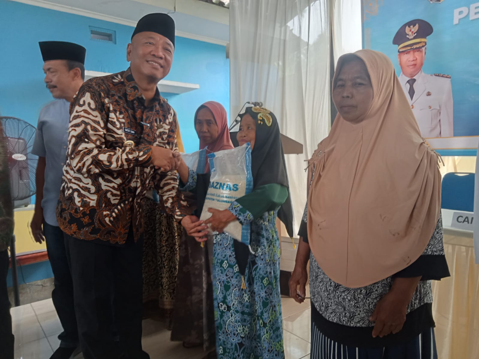 Bupati Tulungagung Gatut Sunu Wibowo menyerahkan zakat fitrah kepada warga di Kantor Kecamatan Bandung, Kamis (27/3/2025).