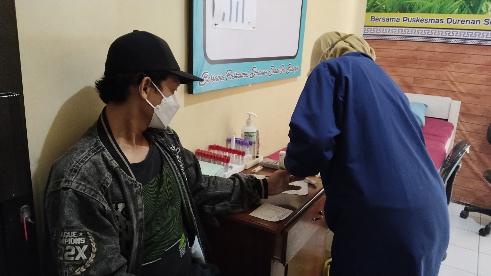 Seorang petugas kesehatan di puskesmas tengah memeriksa kesehatan. Langkah ini merupakan pelayanan optimal saat libur Lebaran, di mana puskesmas beroperasi 24 jam.