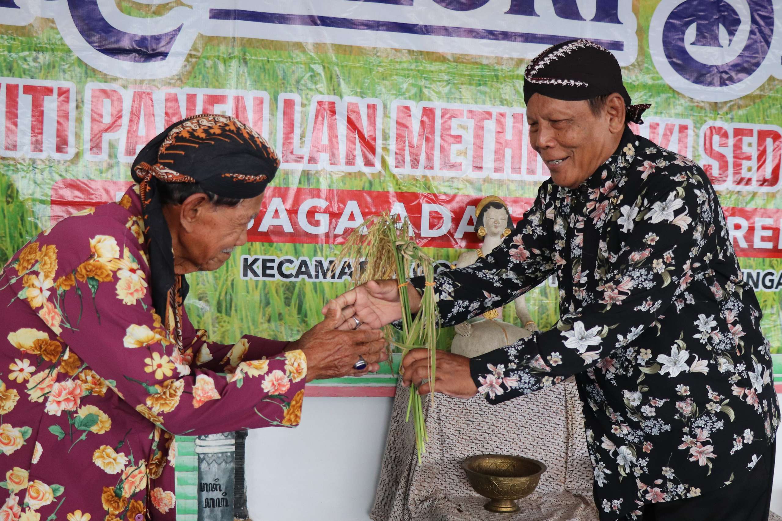 Kades Ngrendeng Nurjiman (kanan) menerima padi secara simbolis. (YOGA DD/RADAR TULUNGAGUNG)