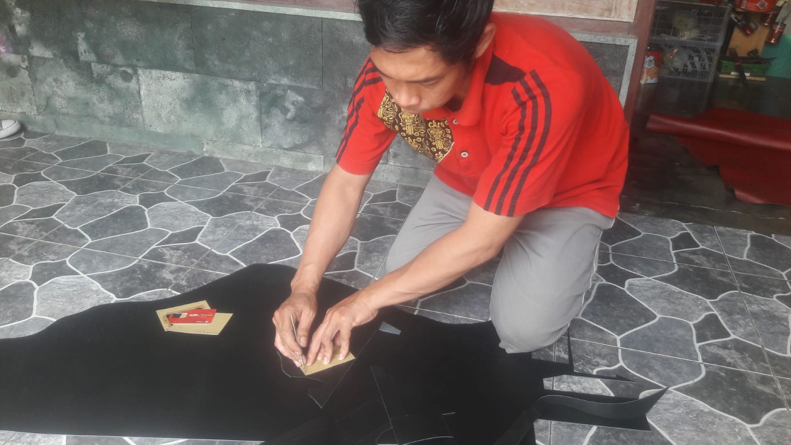 Wahyudi Setiana dalam proses produksi salah satu kerajinan kulit di kediamannya beberapa waktu lalu.