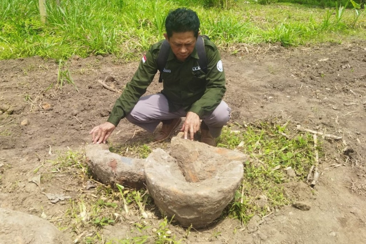 Anggota TACB Tulungagung Hariyadi Pamungkas menunjukkan lumpang batu yang ditemukan di dekat Candi Mirigambar. (TACB TULUNGAGUNG)